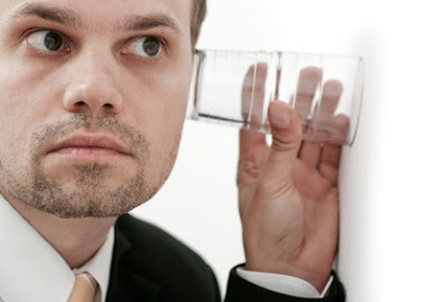 espionage spies man listening through wall with a glass