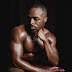 Muscular man sitting on wooden stool