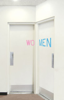 two washroom doors adjacent to each other. One reads wo, the other reads men