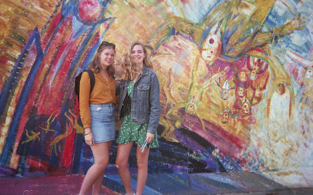 Two girls standing in front of the Berlin wall