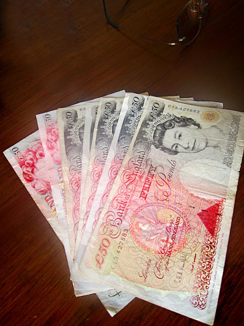 50 pound notes on a wooden desk