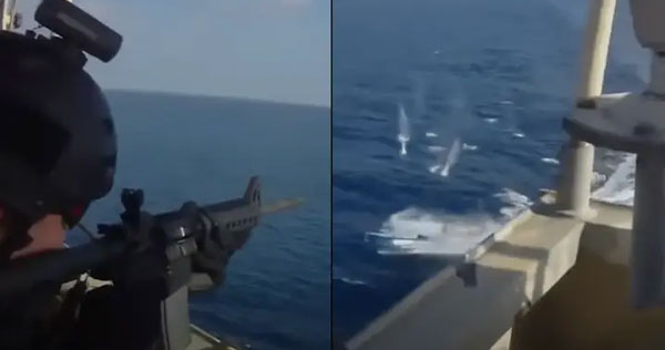 Guardias de seguridad con ametralladoras disparan contra piratas que intentan atacar el barco