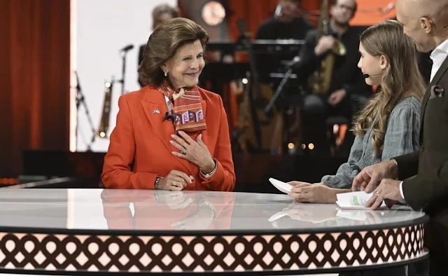 Queen Silvia wore a coral blazer by Georg et Arend. Chanel multicolour silk scarf. Fundraising campaign for Ukraine's children