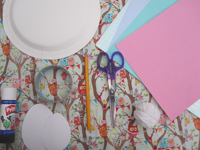 Craft supplies, including card, paper plate, tape, glue, egg template, pencil, scissors, string