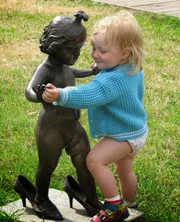 Funny baby girl dancing with statue