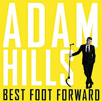 Best Foot Forward audiobook cover. Wearing a black suit, Adam poses with a mic stand, in front of a solid yellow background. 