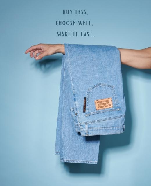 Image of blue denim jeans layed over an outstretched arm, the jeans are against a pale blue backdrop with the text above stating Buy Less, Choose Well, Make it last.