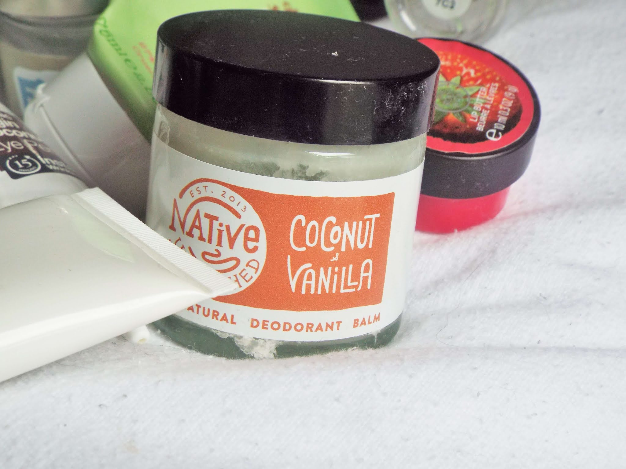 Native Unearthed Natural Deodorant Balm Coconut & Vanilla, packaged in glass jar, with black plastic screw on lid.