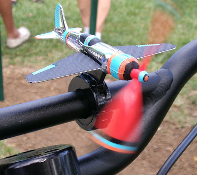 Toy airplane attached to handlebar.