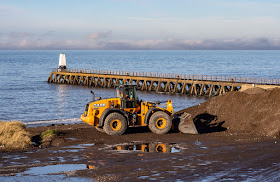 Photo of a digger removing stones from the shore by Maryport Pier