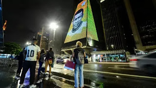 People converged in front of a building in the city of Sao Paulo with the face of Pele splashed on it