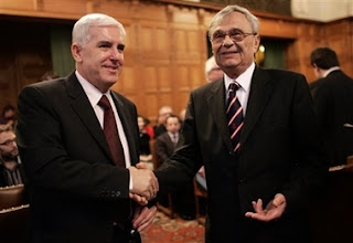 Bosnian agent Sakib Softic, left, shakes hands with Head of the Law Council of the Ministry of Foreign Affairs of Serbia and Montenegro Radoslav Stojanovic at the International Court of Justice, also known as the World Court, in The Hague, the Netherlands, Monday Feb. 26, 2007. The United Nations' highest court began delivering a historic ruling Monday on whether Serbia is responsible for genocide through the killing, torture, rape and expulsion of Bosnian Muslims. It is the first time an entire nation is being held to judicial account for the ultimate crime.