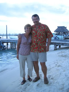 Nan and John at Brisas Grill on Isla Mujeres, with Ballyhoo in background