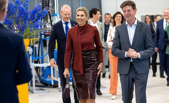 Queen Maxima wore a waxed linen, cactus-leather claret red skirt, and a red scarf blouse by Natan. Edouard Vermeulen