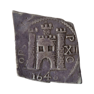 Diamond-shaped silver siege coin, with image of Pontefract Castle and the year 1648 engraved on the front