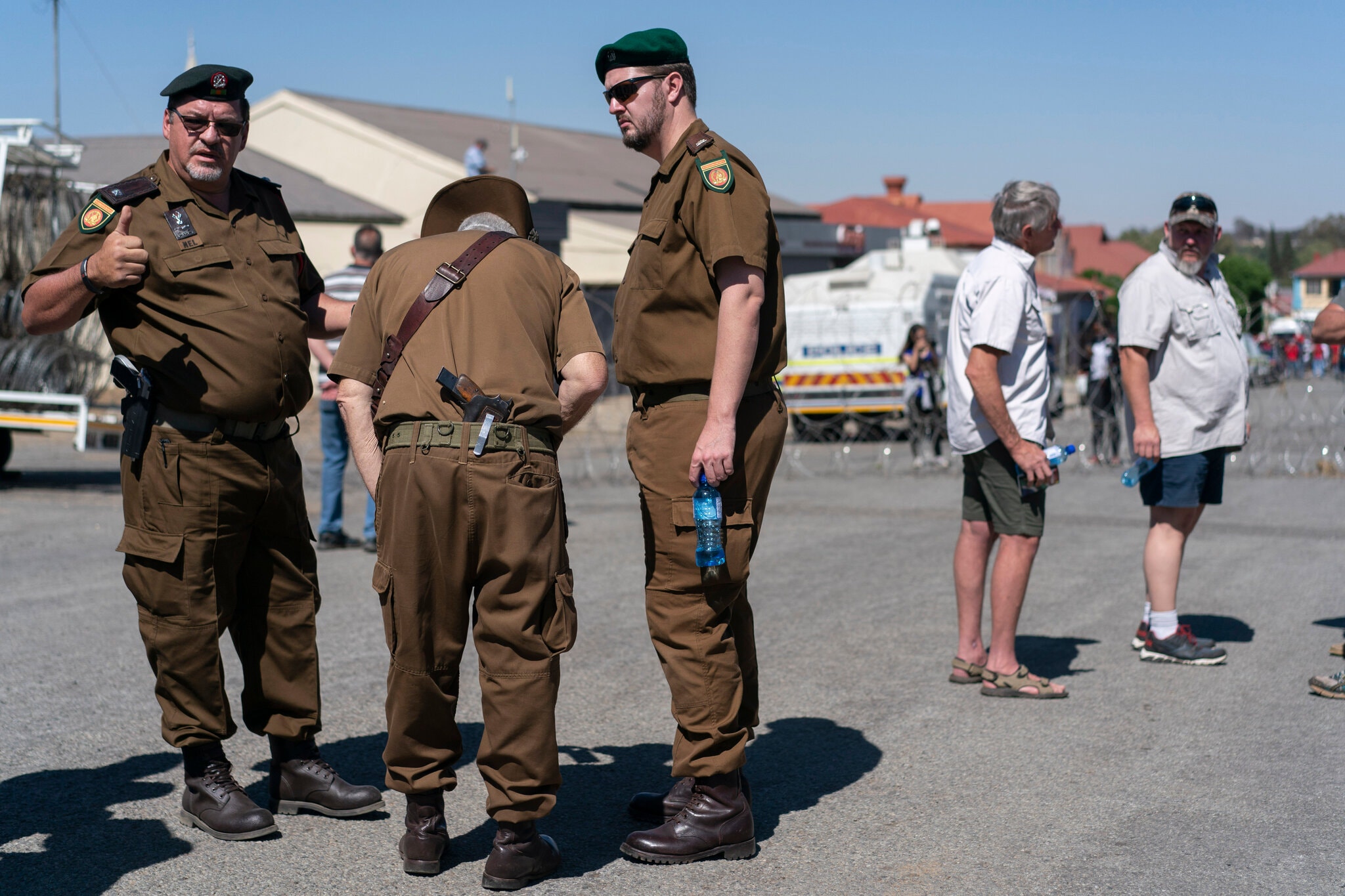 Farmers wearing old South African Army uniforms outside the court.Credit...Joao Silva/The New York Times