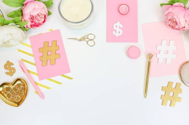 Pink and gold cutouts of hashtags.