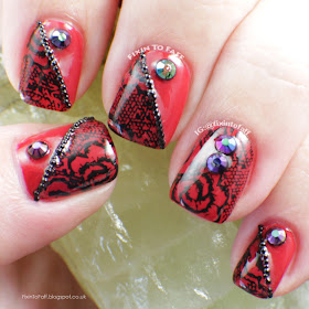 Red and black lace nails with AB rhinestones and microbead accents.