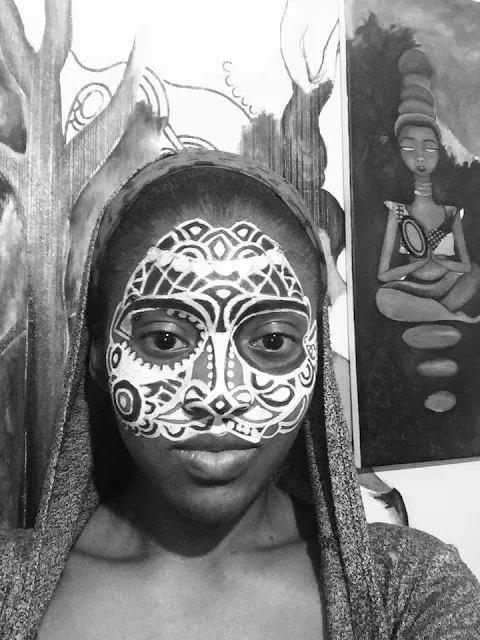 An African lady with a painted on face mask