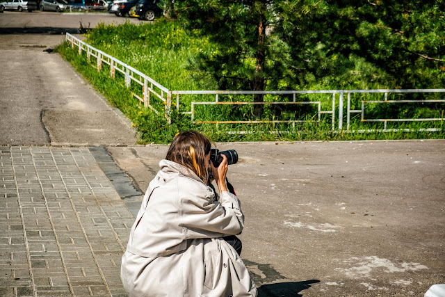 Фотограф на корточках фотографирует