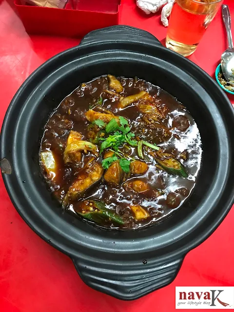 A black medium size claypot with cooked in soy sauce stingray pieces, Chinese style.