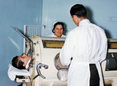 Hospital staff are examining a patient in a tank respirator