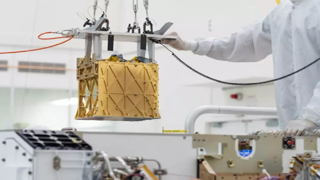 Technicians at NASA's Jet Propulsion Laboratory lower the Mars Oxygen In-Situ Resource Utilization Experiment (MOXIE) instrument into the belly of the Perseverance rover. Credits: NASA/JPL-Caltech