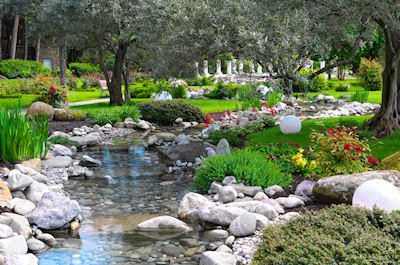 Jardín asiático con río, plantas y flores de colores