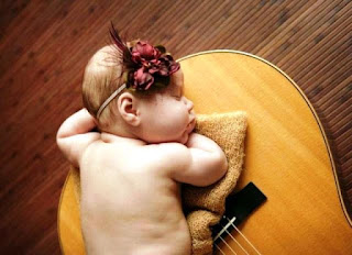 Bayi lucu menggemaskan tidur di atas gitar