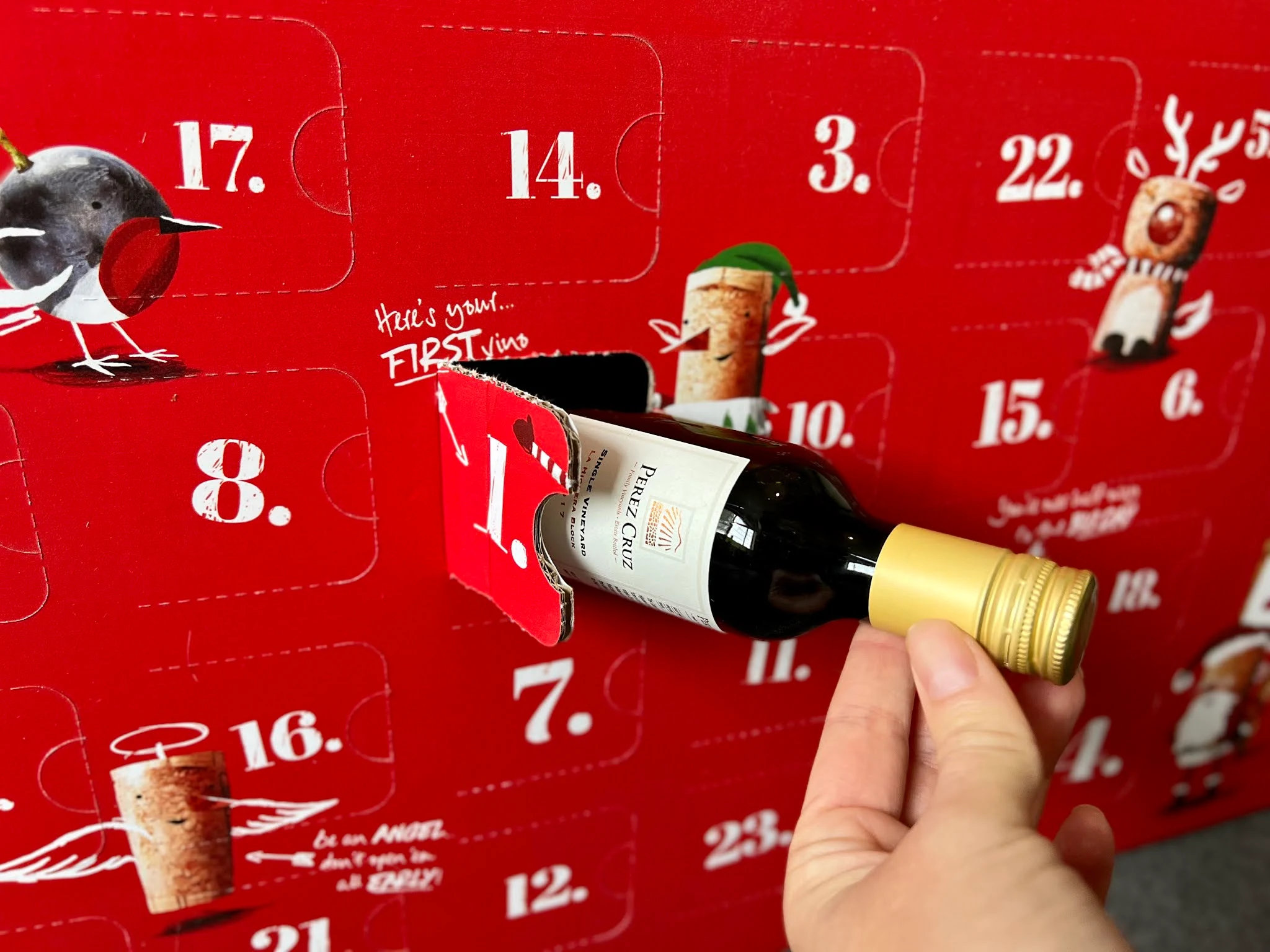 opening door number 1 of the virgin wines red wine advent calendar and pulling out a mini bottle of wine