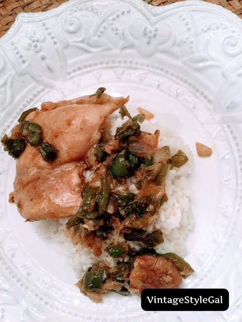 Chicken thighs plated with green pepper and onion over rice