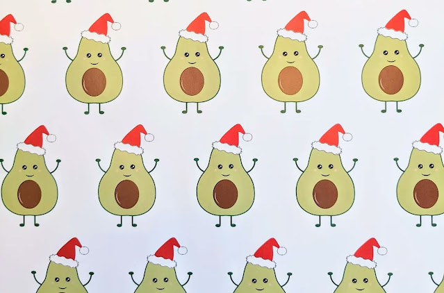 A wrapping paper design, featuring rows of jolly avocados in Christmas hats