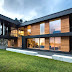 Modern Twofold House In Black Stained Wood With Natural Wood Between The Window Partitions