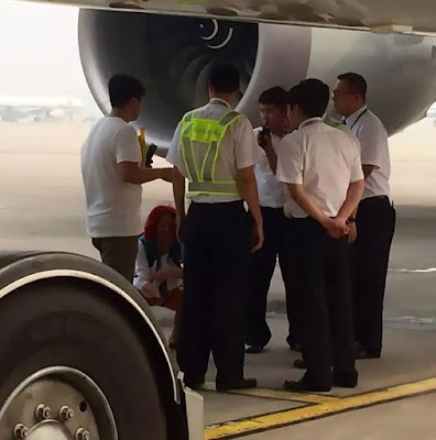 Couple who missed their flight pictured squatting under plane to prevent it from taking off