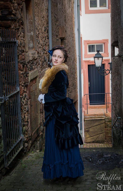 Steampunk Victorian woman wearing blue bustle dress made of velvet