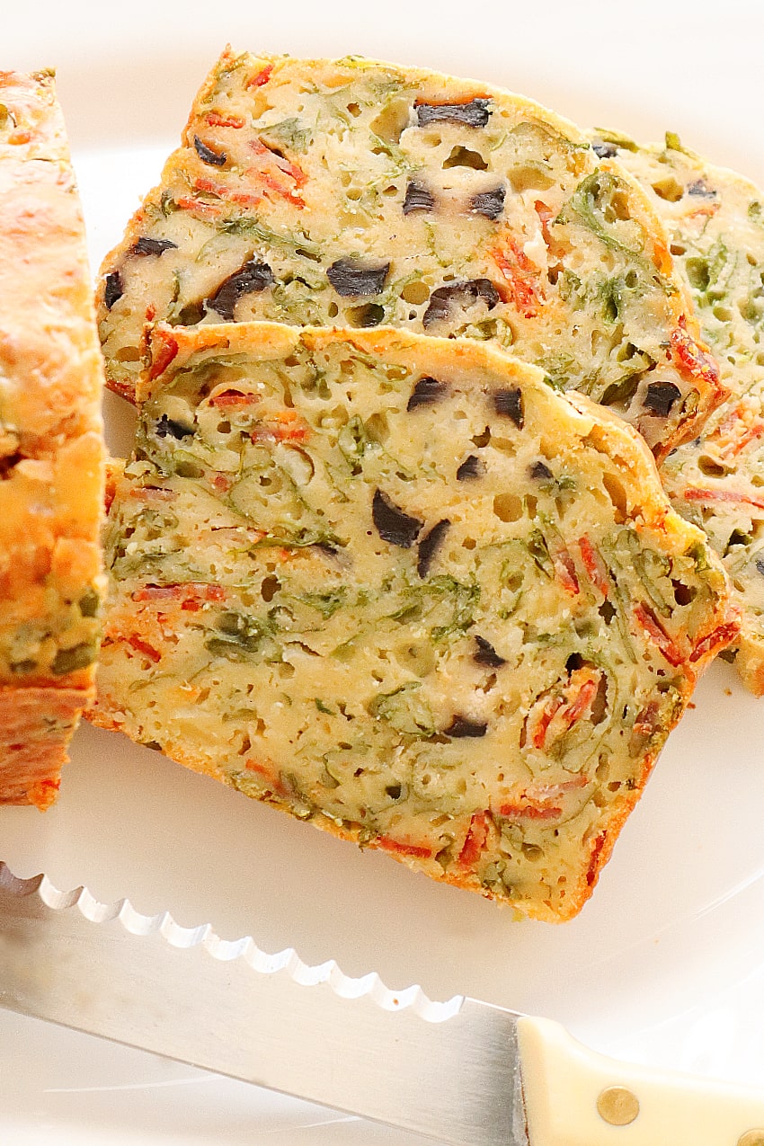 slices of arugula, olives, onion and chorizo bread on a plate