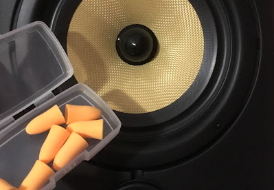 A hi-fi speaker next to a small box of foam ear plugs.