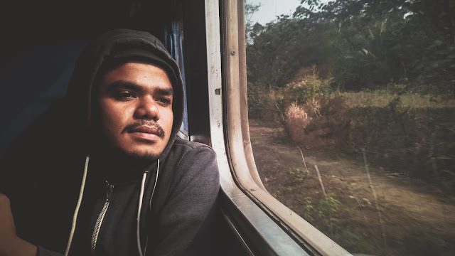 teman traveling saya, Yoman sedang berpose di kaca jendela kereta api lokal menuju merak