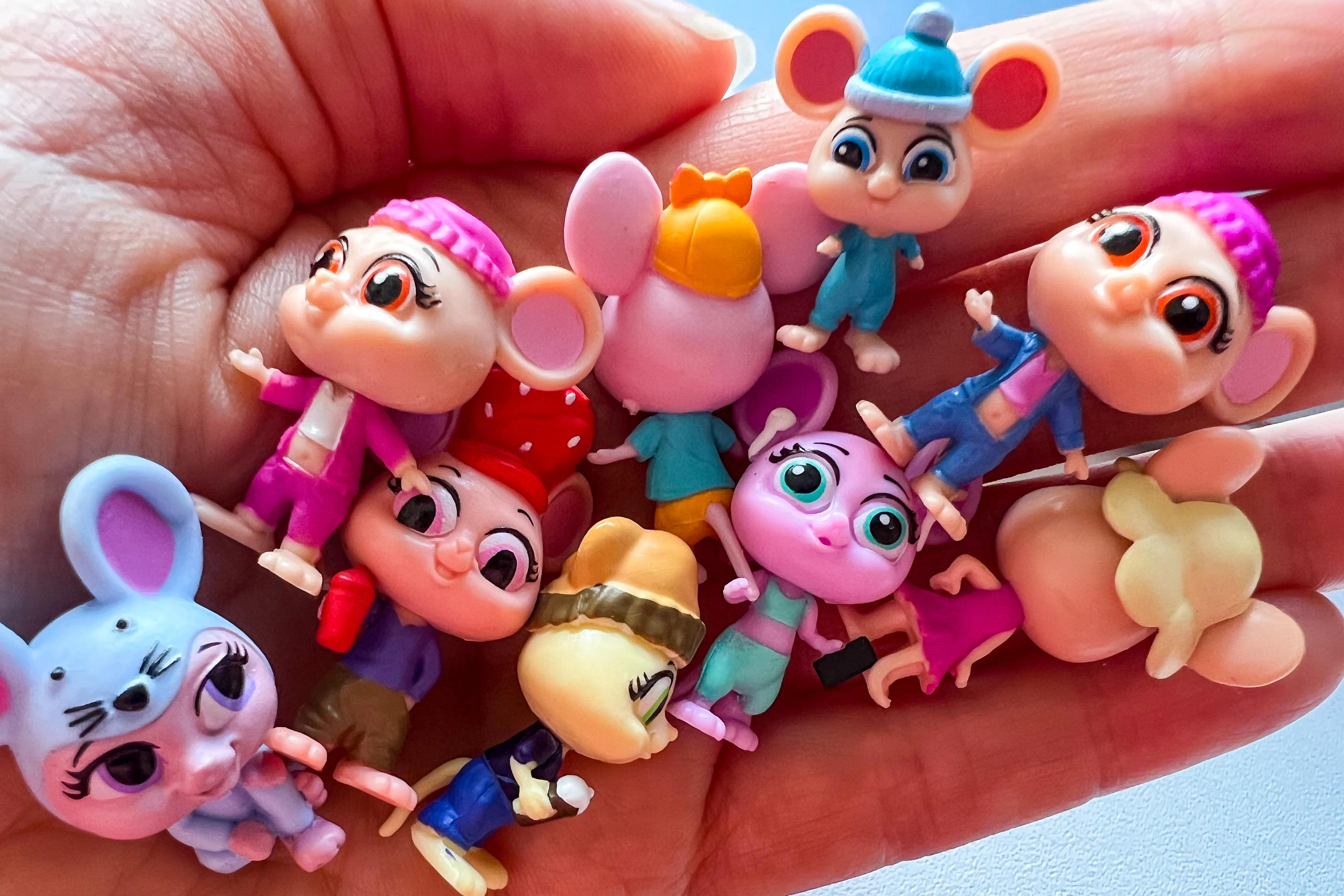 A hand full of small plastic mice toys from Millie & Friend Mouse In The House range