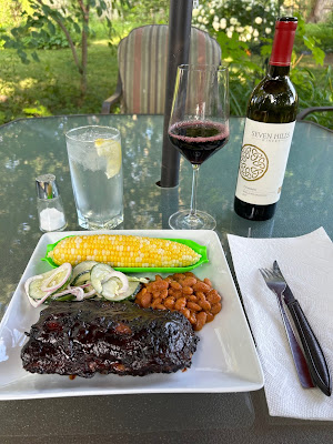 Barbecued baby back ribs with roasted corn on the cob, mustard baked beans and cucumber salad