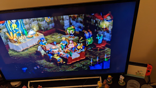 Off screen shot: Ogre Battle 64: The heroes sit around a table having a party.