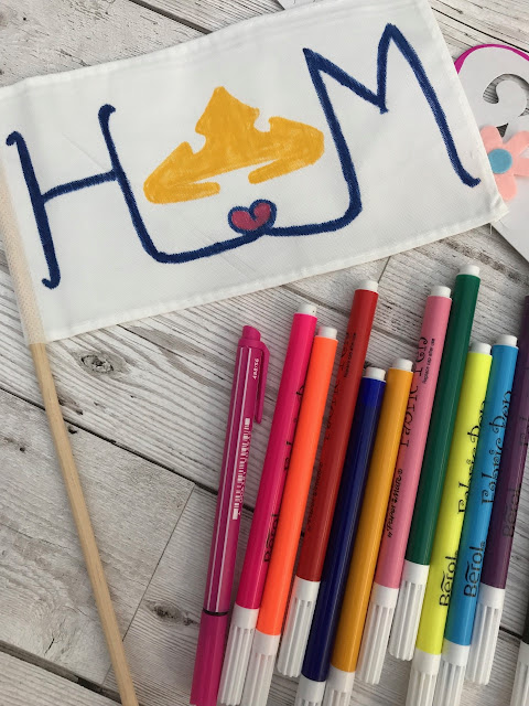 The decorated flag with felt tips laid beside it