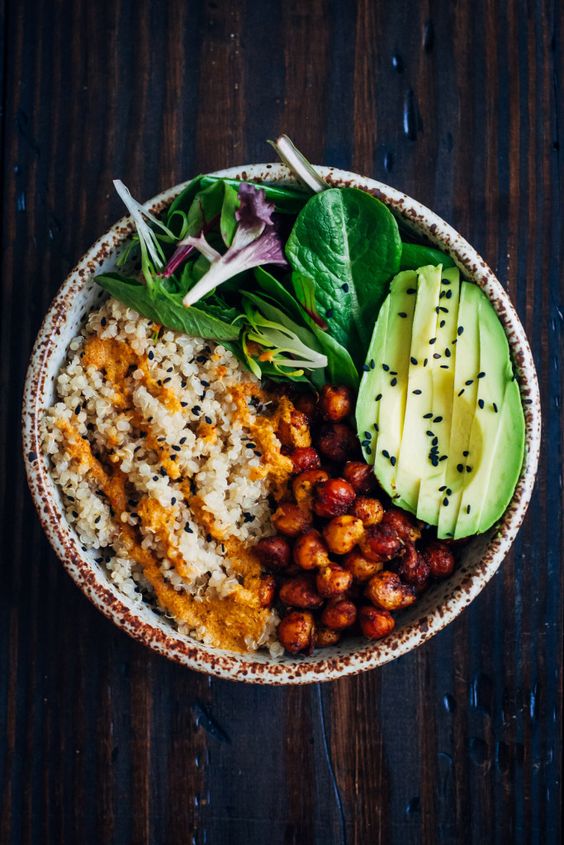 This vegan buddha bowl has it all - fluffy quinoa, crispy spiced chickpeas, and mixed greens, topped with a mouthwatering red pepper sauce! RECIPE UPDATED December 2017.