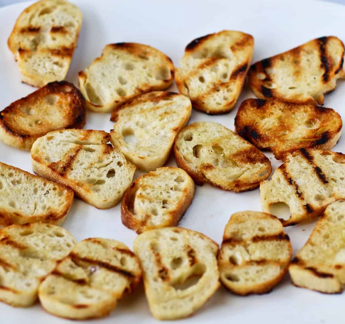 Grilled baguette croutons on a plate.
