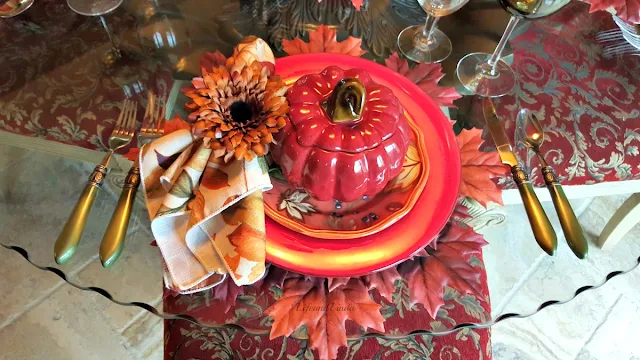 red pumpkin soup tureen with leaves salad plate and napkin ring