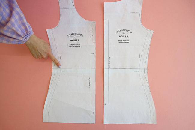 Finger pointing to lengthen/shorten waist  line on the bodice pattern pieces of Agnes