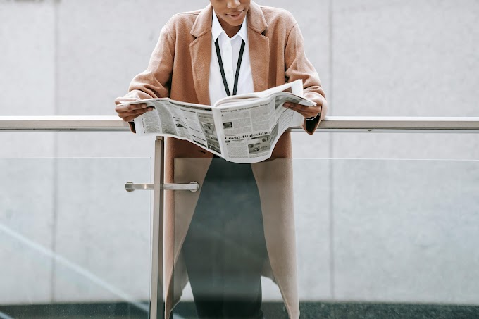 Mulher em pé lendo o jornal