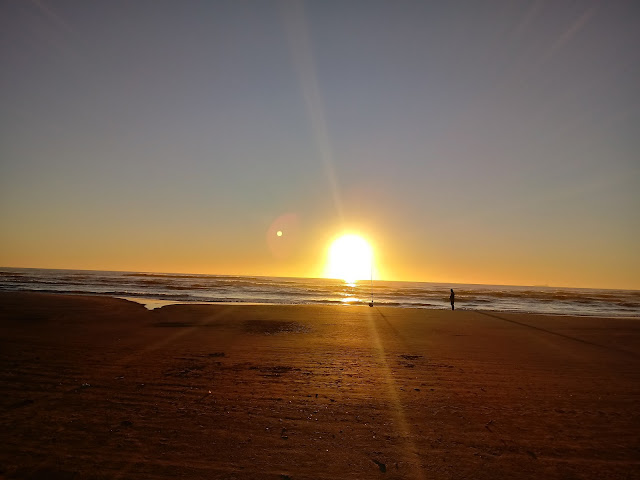 A foto mostra o nascer do Sol em alguma praia do Brasil.