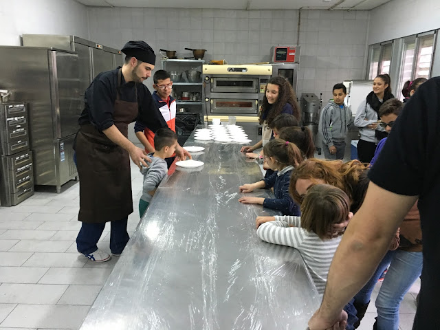 la imagen muestra al cocinero explicando a los afiliados la elaboración de la masa para pizza