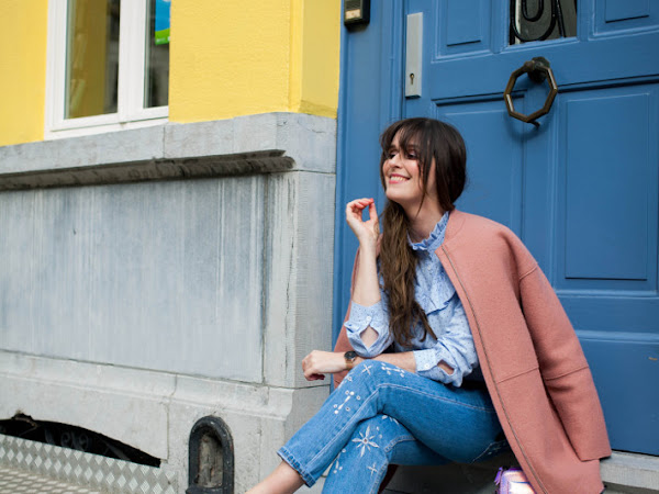 Outfit: embroidered jeans, pink coat, yellow wall